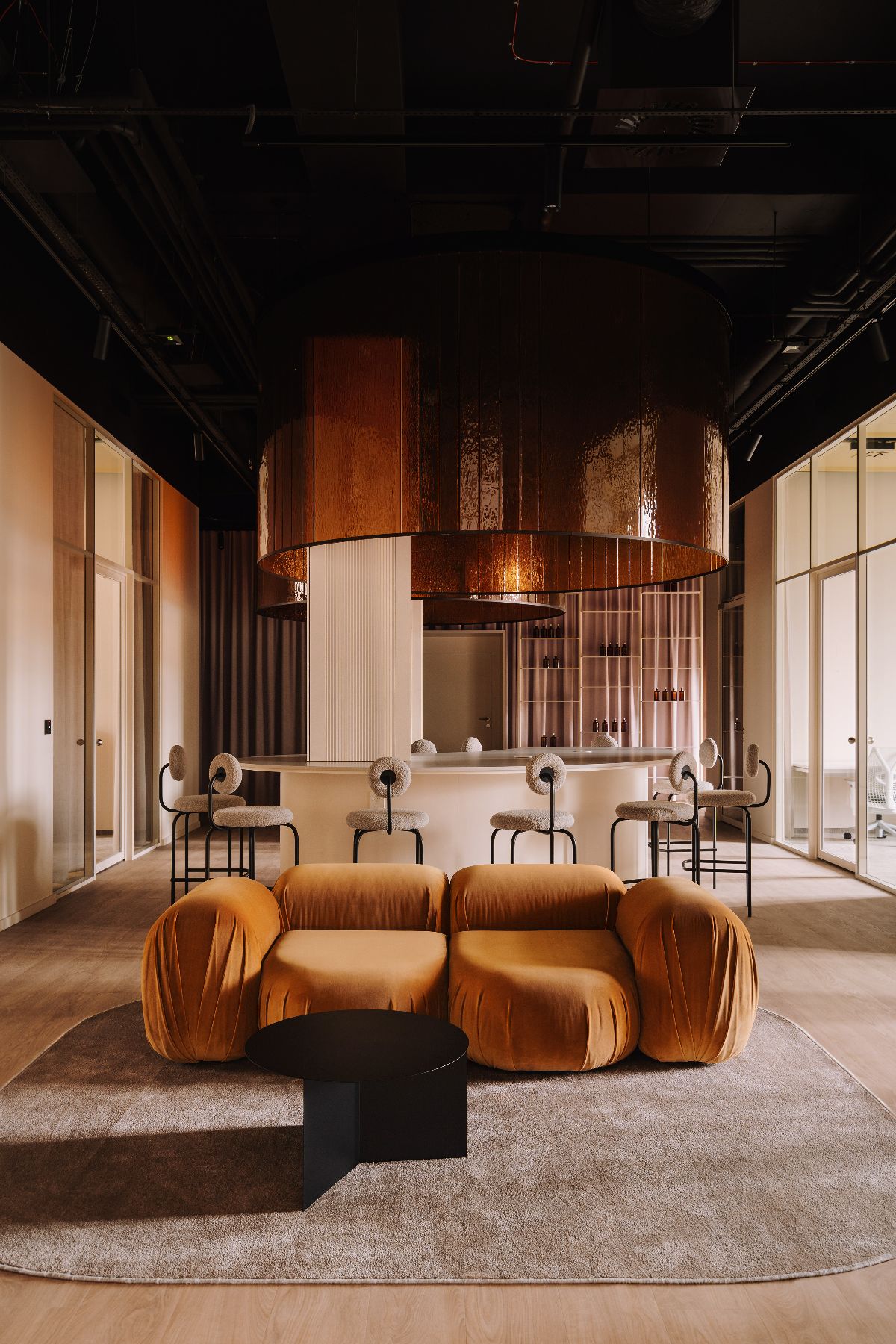 Szkło pod sufitem i elementy fali – zjawiskowa przestrzeń do pracy w ciepłych tonach