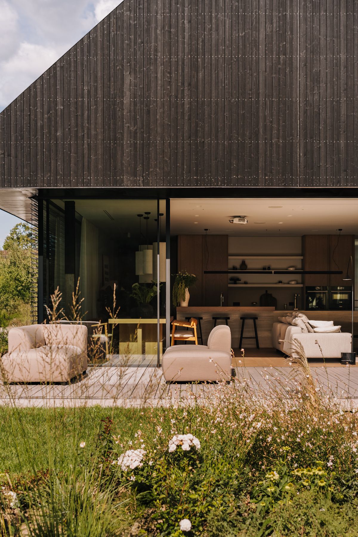 Naturalne barwy, wielowymiarowe faktury – dom przy ścianie lasu