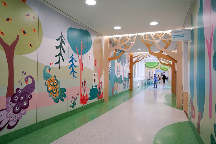 kolorowy korytarz w szpitalu projektu Francisco Rubio Ordás grafiką lasu w wersji rysunkowej