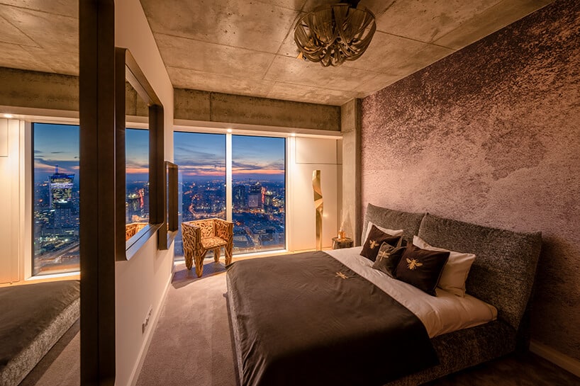 duże łóżko w sypialni z dużym lustrem w apartamencie Nature na Złotej 44