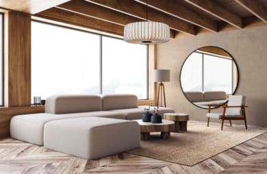 minimalistyczna przestrzeń z prostą bryłą szarej kanapy przy lampie na trójnogu