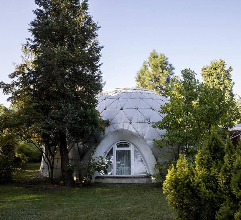 wyjątkowy mały budynek w kształcie kopuły z owalnym oknem pośród drzew