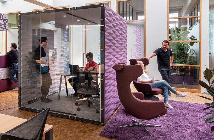 nowoczesny fotel obrotowy od VANK obok fioletowego boksu akustycznego VANK w nowoczesnej przestrzeni biurowej