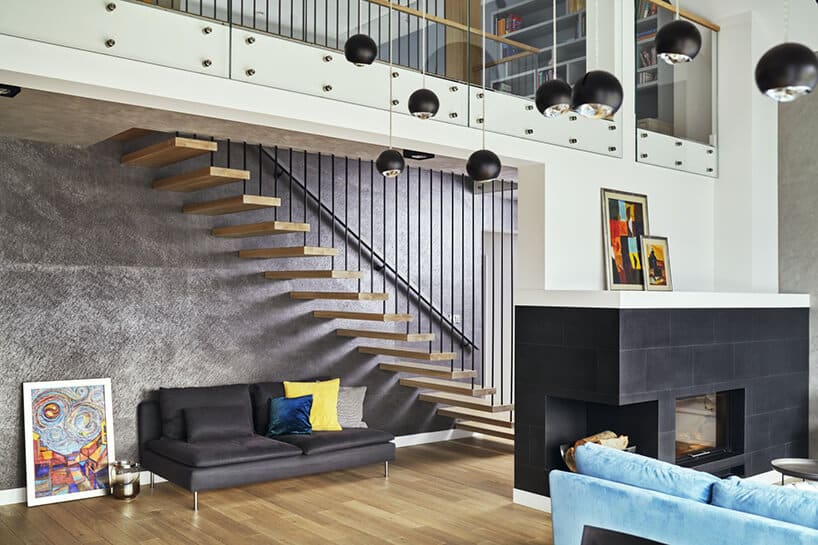 nowoczesne wnętrze domku jednorodzinnego z drewnianym schodami na tle szarej ściany