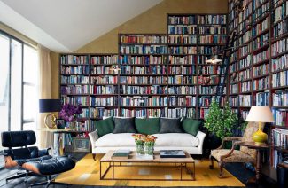 dwie ściany w salonie z białą sofą jako domowa biblioteka pełna książek