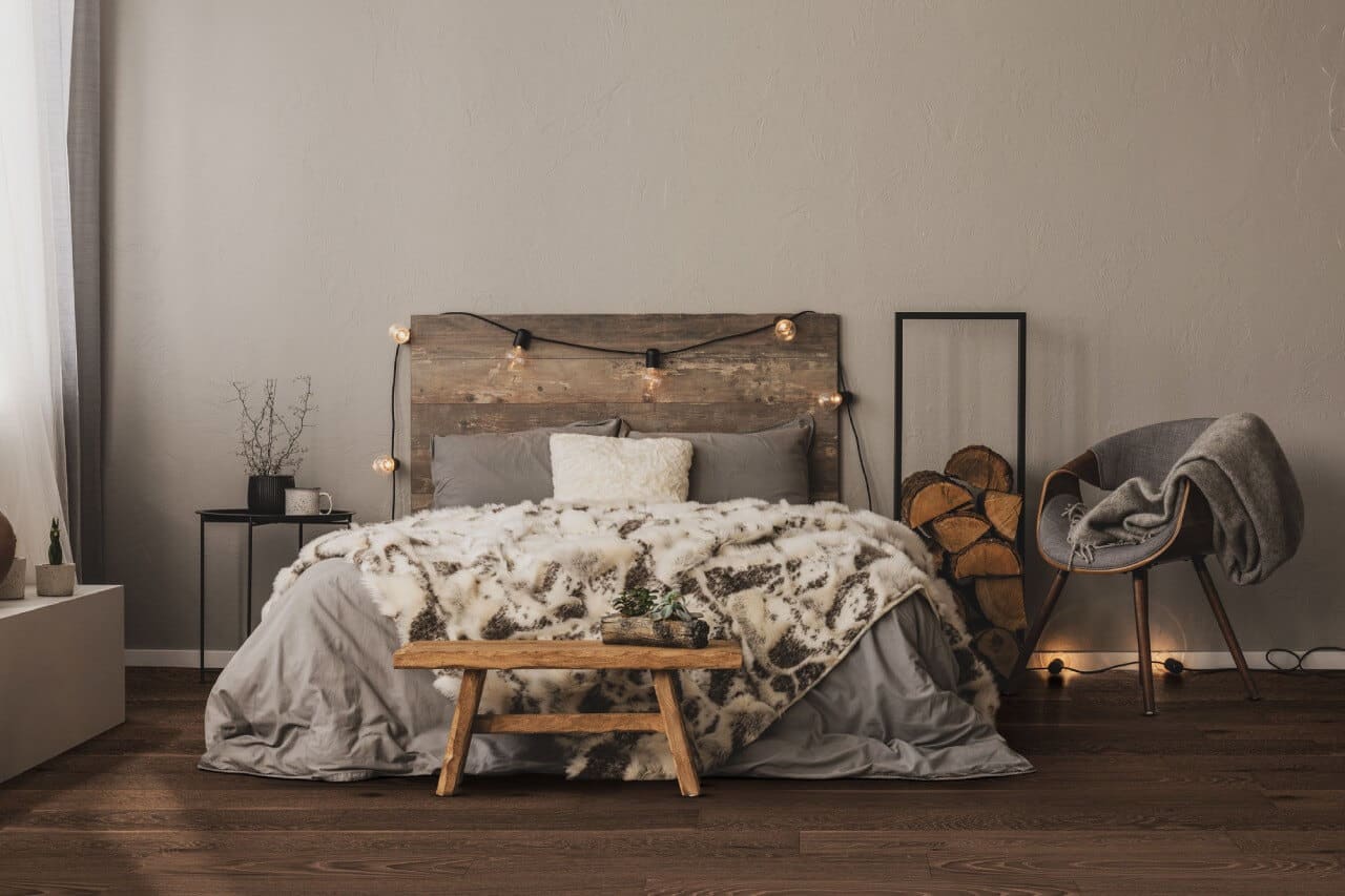 duże łóżko z zagłówkiem w sypialni z drewnianą podłogą