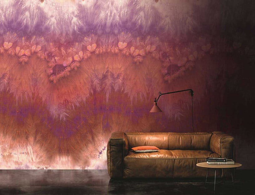 brązowa skórzana kanapa na tle wyjątkowej tapety fioletowo-czerwono-białej