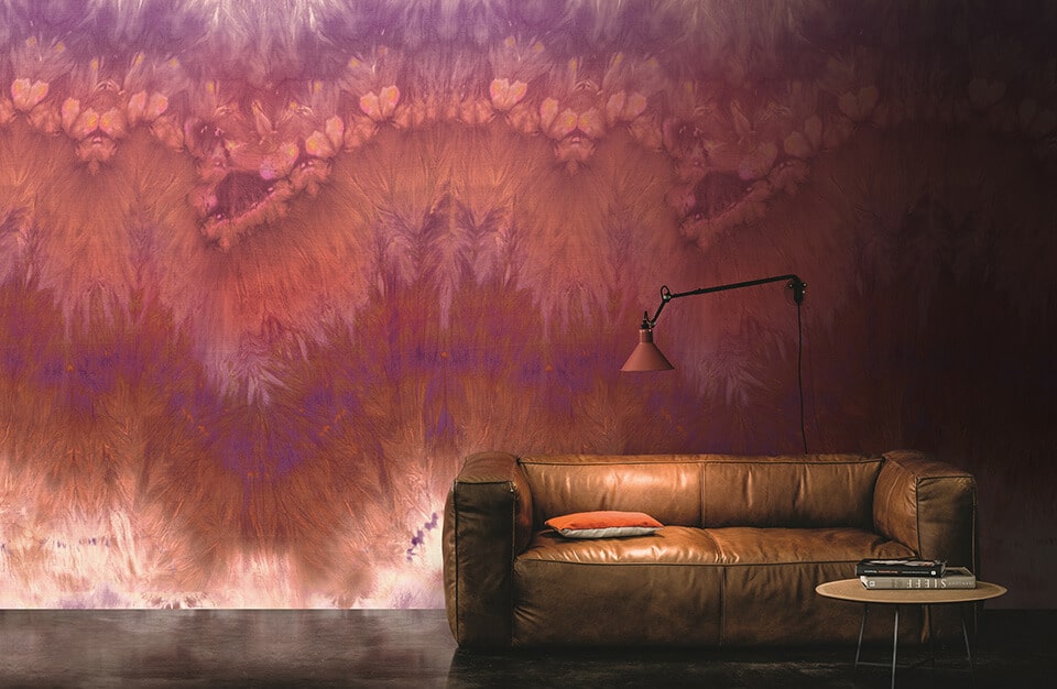 brązowa skórzana kanapa na tle wyjątkowej tapety fioletowo-czerwono-białej