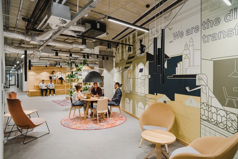 nowoczesne wnętrze open space intive troje pracowinków przy drewnianym stoliku