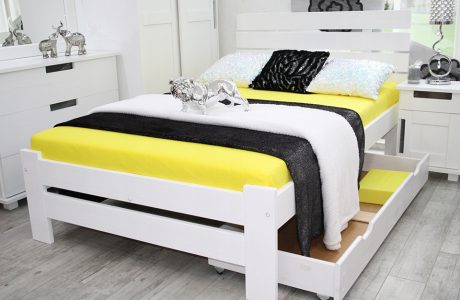 białe wysokie łózko z żółtym materacem w jasnej sypialni z szara podłogą