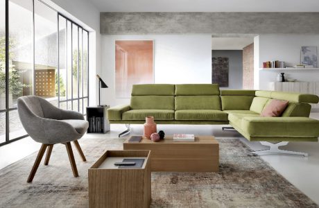 zielona sofa w przestronnym salonie z wysokimi oknami