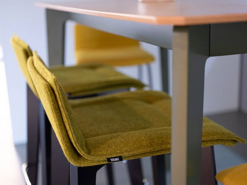 krzesła z żółtym siedziskiem wsunięte pod stół