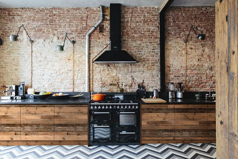 szafki z litego drewna na pasiastej podłodze w kuchni z granitowo-czarnym blatem