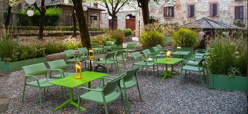 ogórdek z zielonymi krzesłami i stolikami i nietypowymi lampkami na stolikach