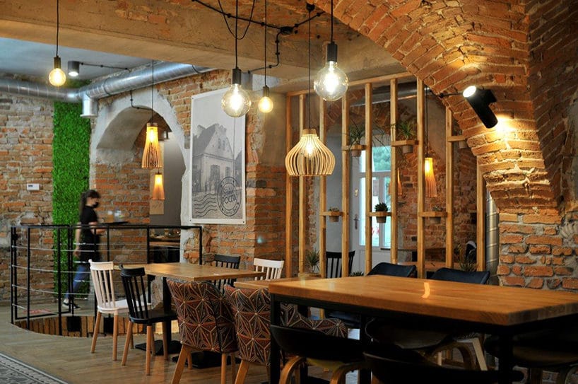 wnętrze restauracji w starej poczcie z ceglanymi ścianami i łukami projektu CONSIDO