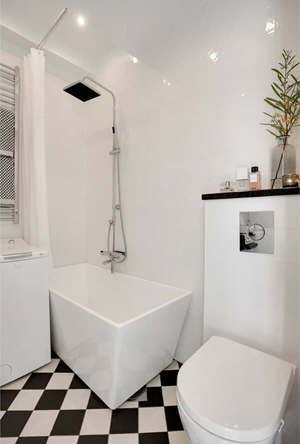 biała łazienka z biało-czarnymi płytkami na podłodze