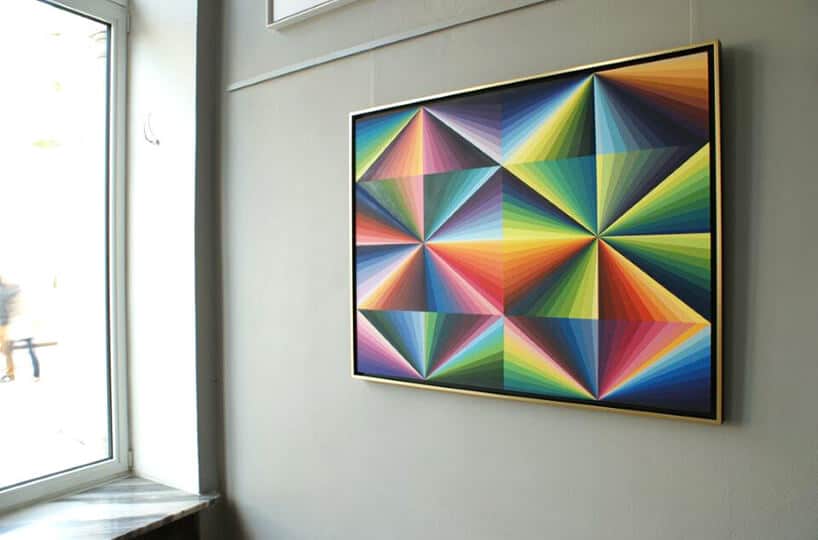 obraz z kolorowych trójkątów na tle szarej ściany