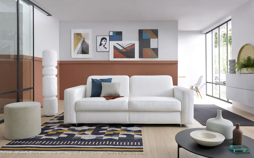elegancka minimalistyczna biała sofa Sora od Gala Collezione w białym salonie z dywanami
