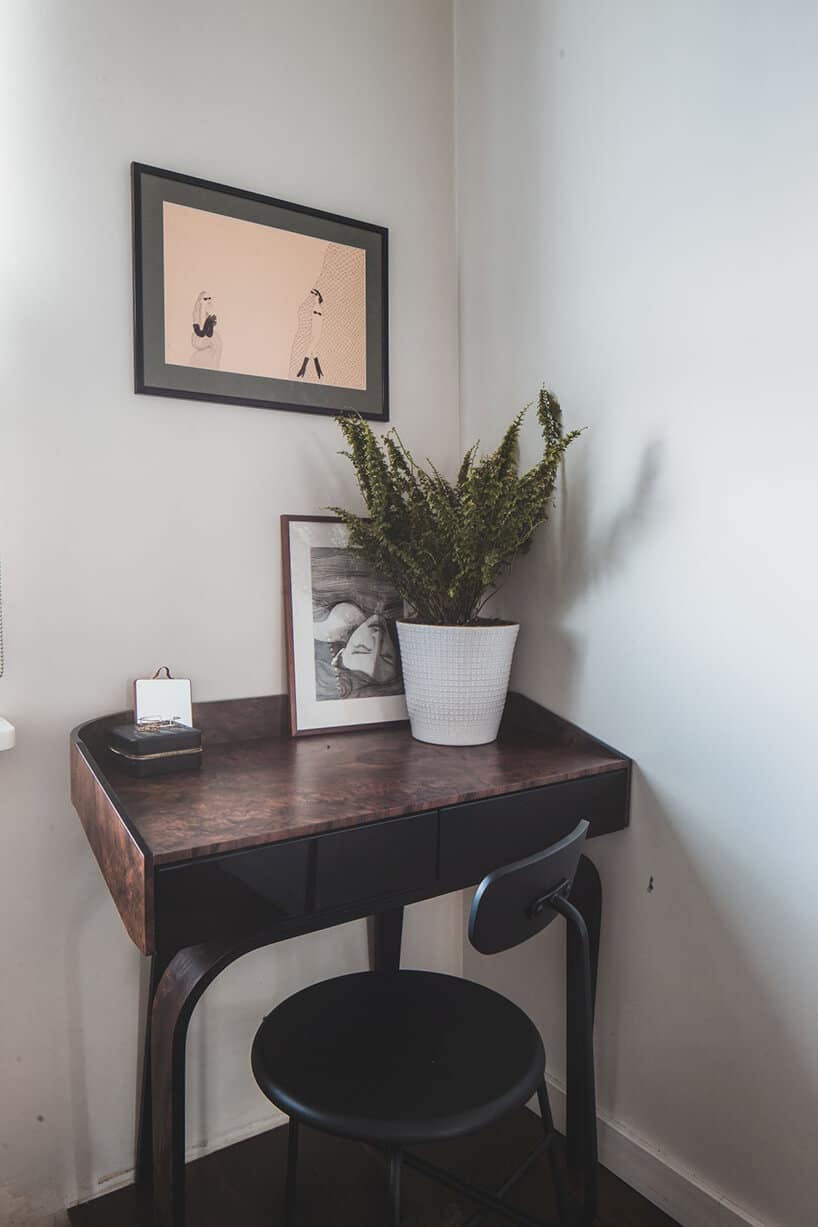 minimalistyczne wnętrze od Taff Architekci mały ciemny stolik z czarnym krzesłem w narożniku białego pokoju