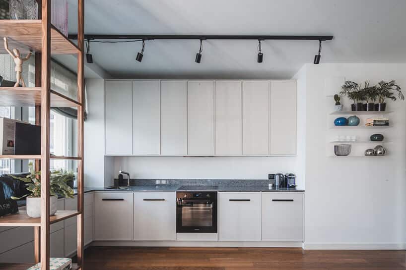 minimalistyczne wnętrze od Taff Architekci biały aneks kuchenny z szarym kamiennym blatem na białych szafkach