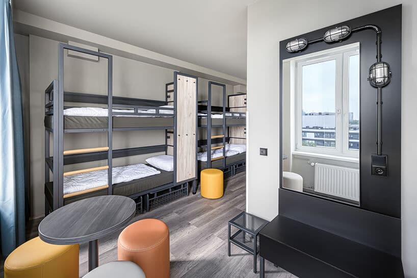 pokój hotelowy z łóżkami piętrowymi z szarą konstrukcją i surowym stylem