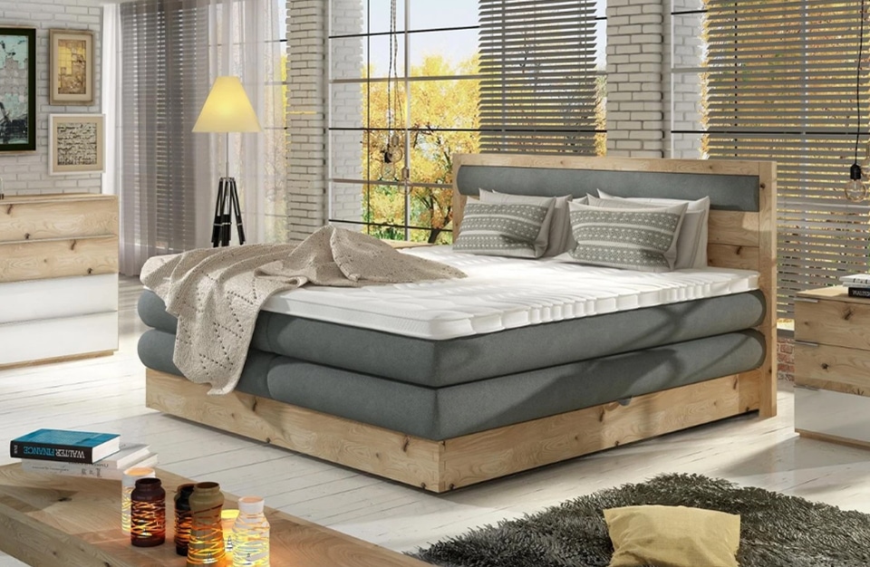 duże drewniane łóżko wykończone szarym materiałem w eleganckim salonie