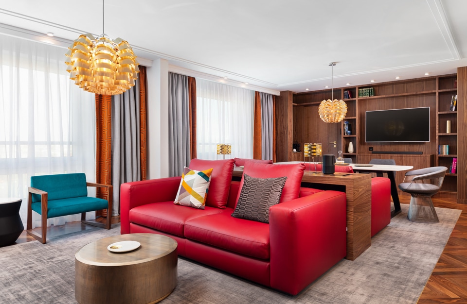 hotel Sofitel aranżacja apartamentu salonu z czerwoną sofą