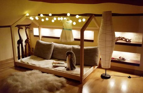 drewniane łóżko domek od Oliveo w ciemnym delikatnie oświetlony