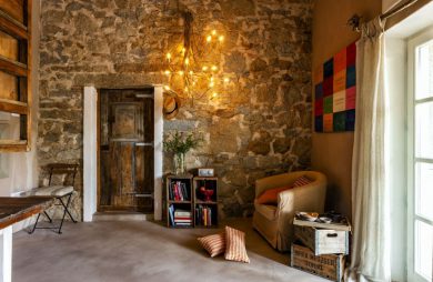 nowoczesna lampa Turciù od Catellani&Smith na kamiennej ścianie ze starymi drewnianymi drzwiami