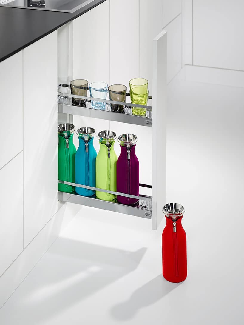 system przechowywania od PEKA wąskie białe cargo z kolorowymi termosami i szklankami w białej nowoczesnej kuchni