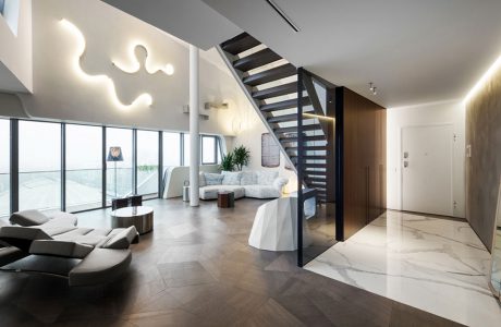 elegancki penthouse od Zaha Hadid elegancki wysoki salon z ciemną drewniana podłoga i ciemnymi schodami na górę