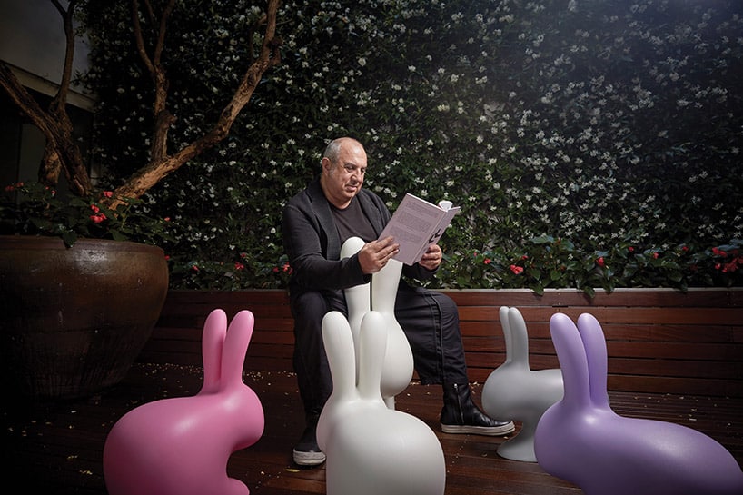 czytający mężczyzna otoczony plastikowymi królikami
