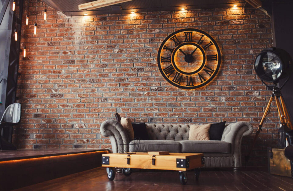 Loftowe wnętrze z tapicerowaną kanapą i cegłami na ścianie
