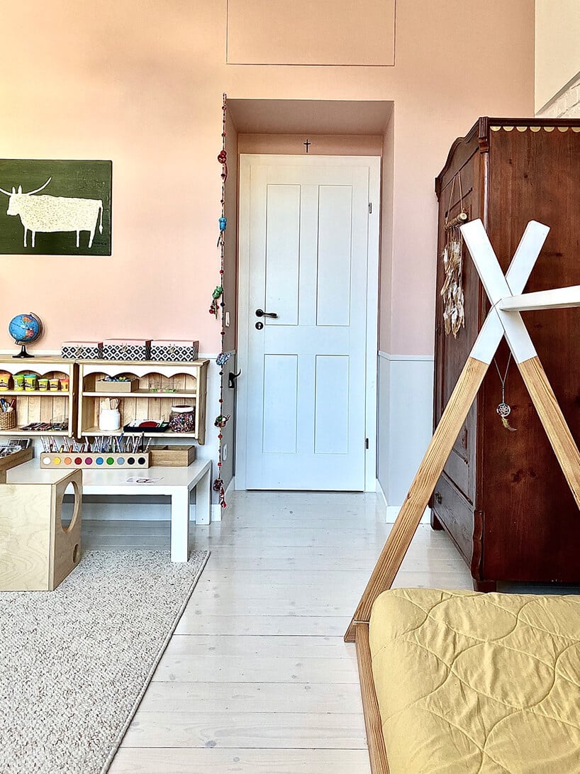 pokój dziecięcy w stylu Montessori od KUUDO drewniane siedzisko z materacem na tle starej brązowej szafy