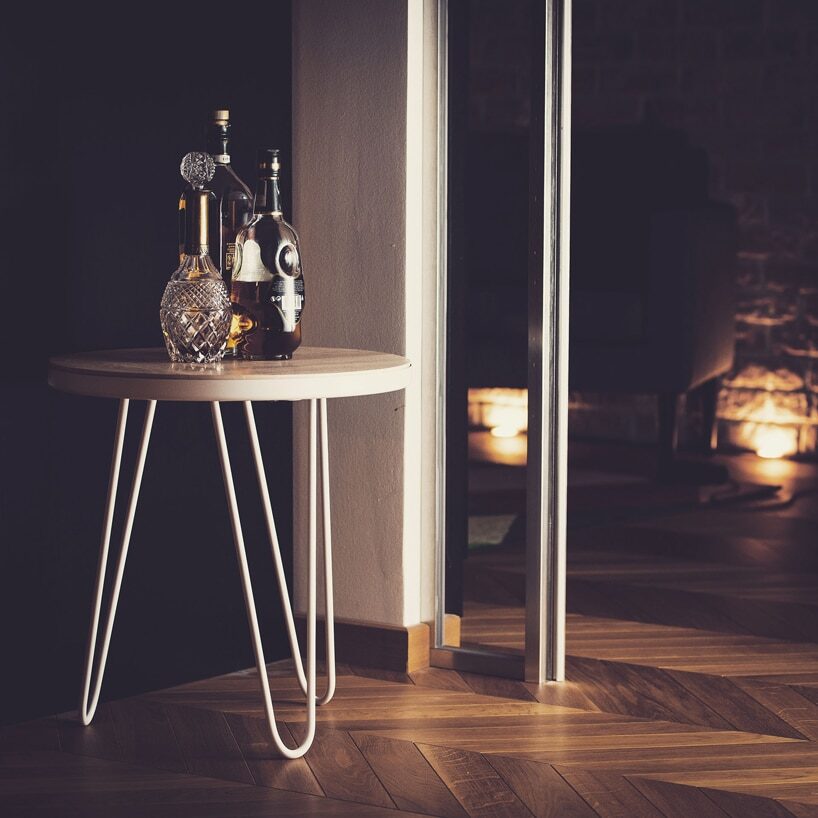 elegancki drewniany stolik Stolik Yggr od Manufaktura Dobek & Stypińska na białych nogach