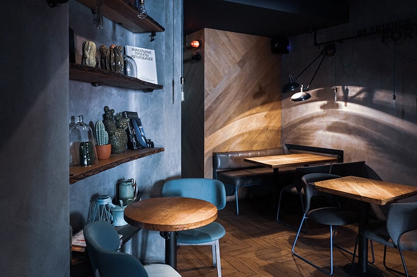 wnętrze restauracji ze stolikami z drewna oraz krzesłami w kolorze niebieskim oraz czarnym skózanym