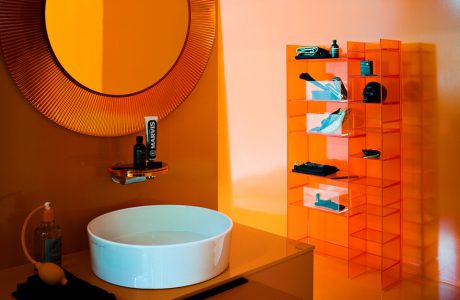 łazienka z pomarańczową przeźroczystą szafką, regałem i rama lustra od Kartell by Laufen