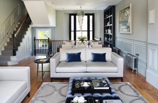 białe eleganckie wnętrze w stylu angielskim z białą sofą z dużą niebieską plisowaną pufą