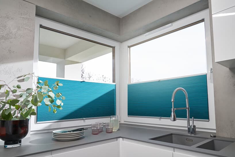 biała kuchnia z szarym blatem pod dwoma dużymi oknami z niebieskimi dwukierunkowymi osłonami okiennymi od ANWIS