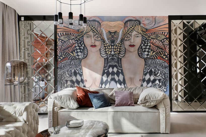 beżowa kanapa z kolorowymi poduszkami w salonie z graffiti z kobietą na ścianie