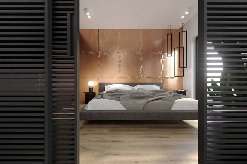 sypialnia z dużym łóżkiem i miedzianymi płytami na ścianie za łóżkiem