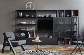 czarna metalowa szafka drewniany stoliczek i dwa krzesła na tle szarej ściany