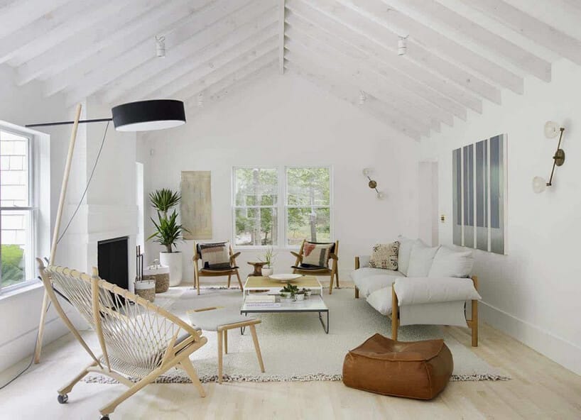 biała aranżacja salonu z kominkiem w stylu skandynawskim z fotelami i sofą