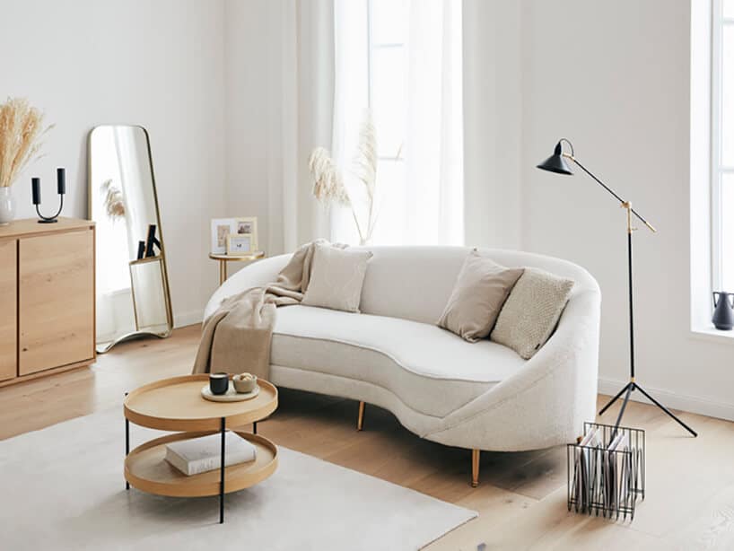 białe wnętrze z długimi zasłonami oraz kanapą w kształcie fasolki