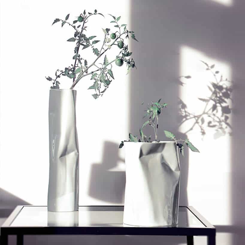 białe powgniatane wazony na szklanym stole przy białej ścianie