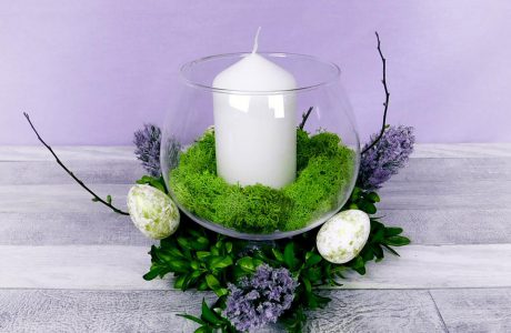 stroik ze szklanego wazonu z mchem i świecą w środku