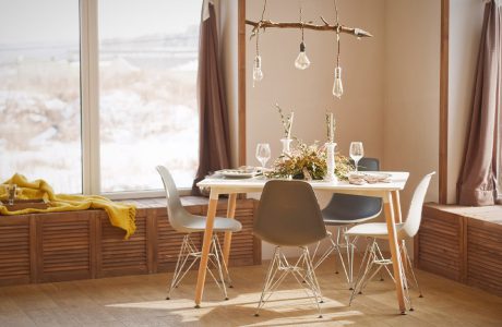 elegancka mała jadalnia z drewnianym stołem z czterema krzesłami pod żyrandolem z drewnianego patyka