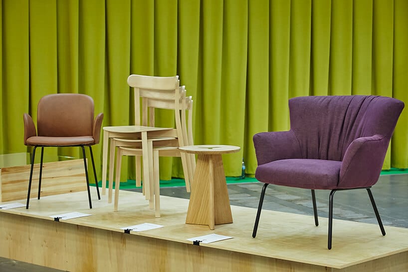 arena design 2020 - fioletowe krzesła na drewnianym podeście z zieloną zasłoną w tle