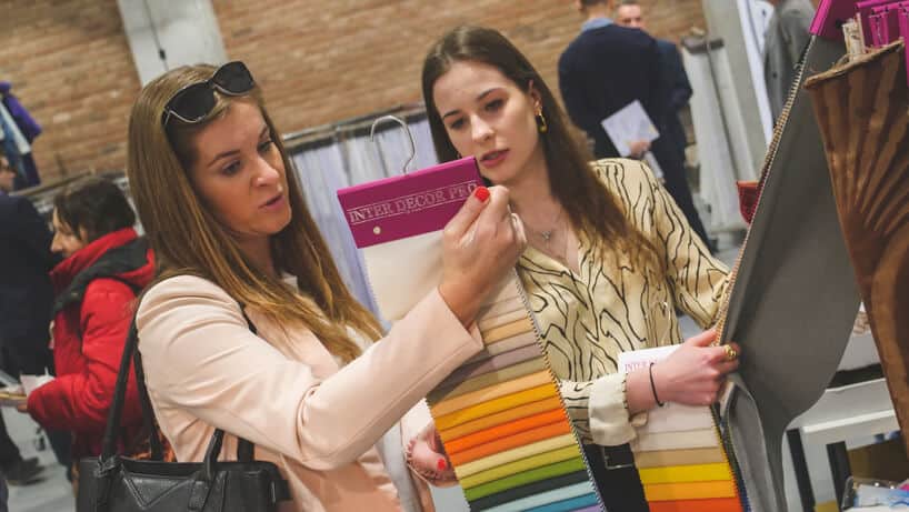 dwie kobiety oglądające próbki materiału