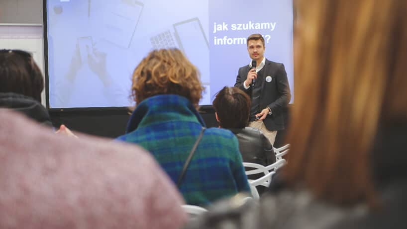 mężczyzna w garniturze podczas wystąpienia